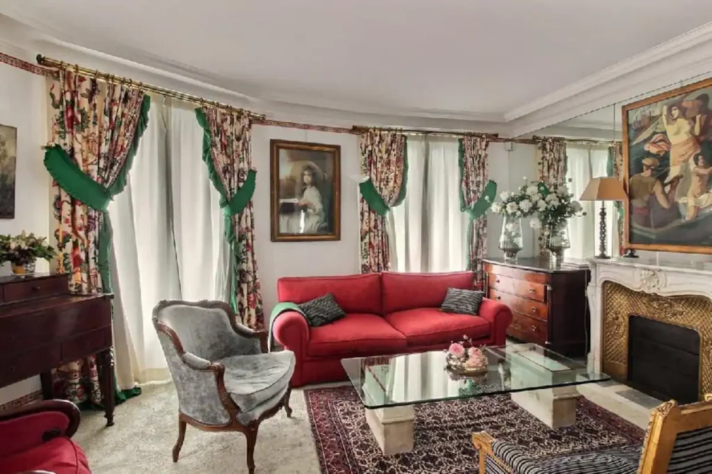 The cozy seating area with sofas, chairs, and a coffee table arranged around a grand decorative fireplace.